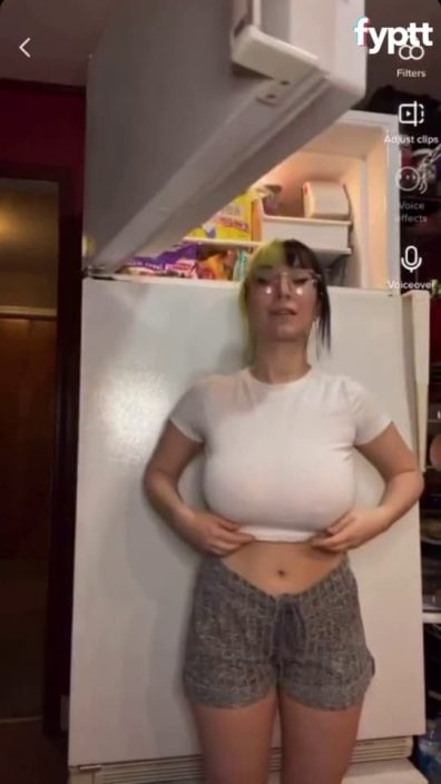 Small petite teen drops her big TikTok tits next to a big fridge