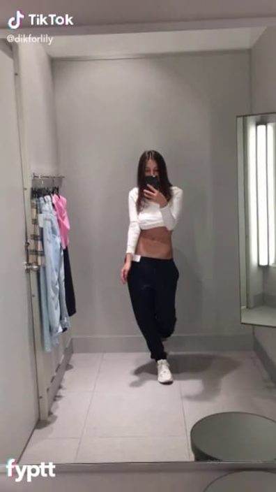 Hot fit brunette making nude TikTok in the fitting room