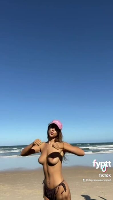 Topless girl showing her tanned TikTok tits on the beach