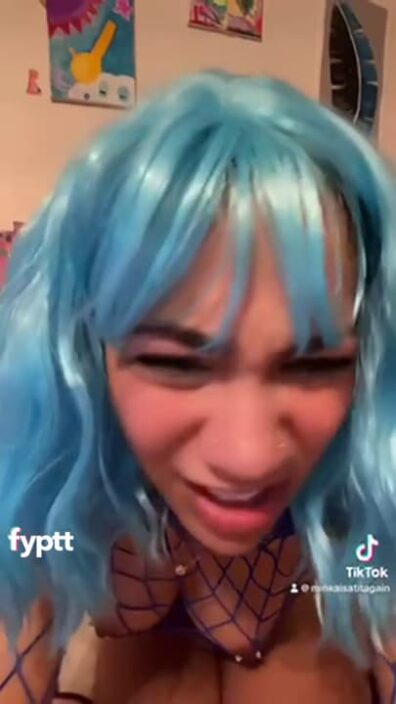 Cyan colored hair girl making NSFW TikTok with her pierced tits and fish net suit