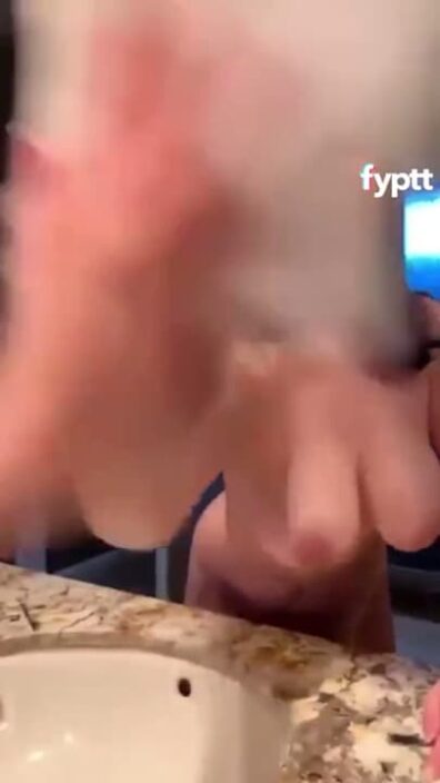 Short girl wiping the mirror to reveal her big natural boobs